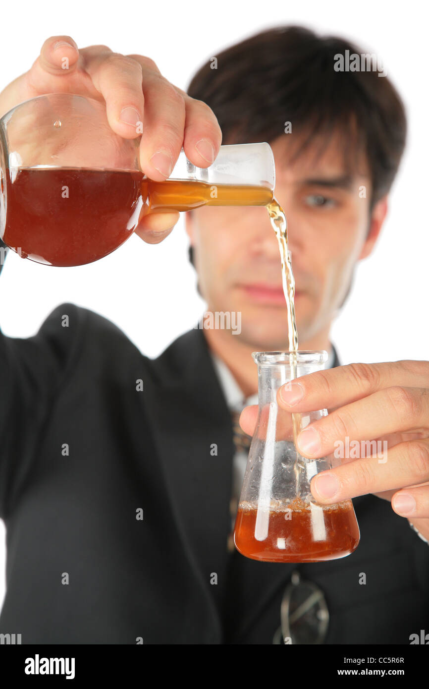 Scientist pours brown liquid from one flask in another Stock Photo