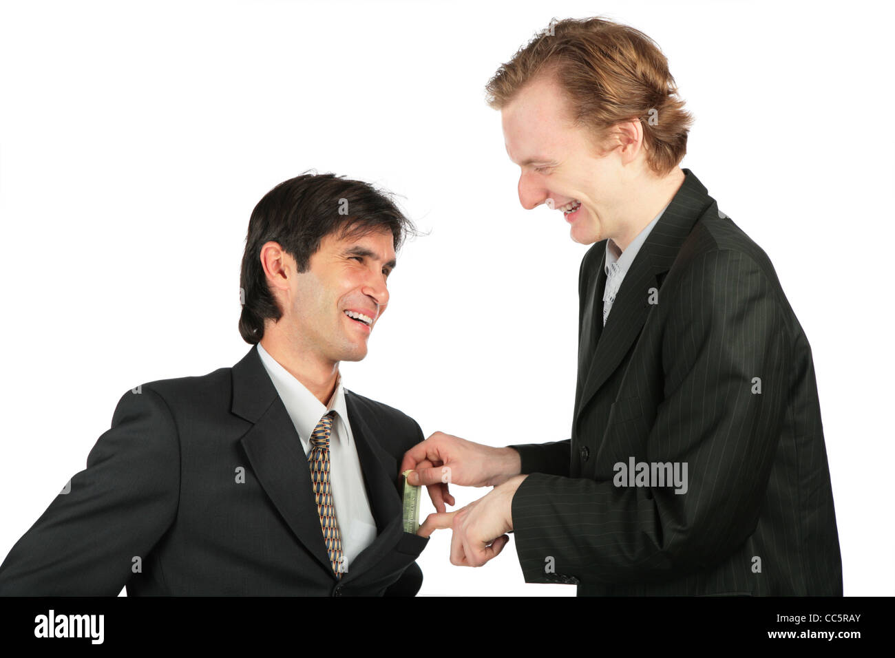 One businessman places to another money into pocket Stock Photo