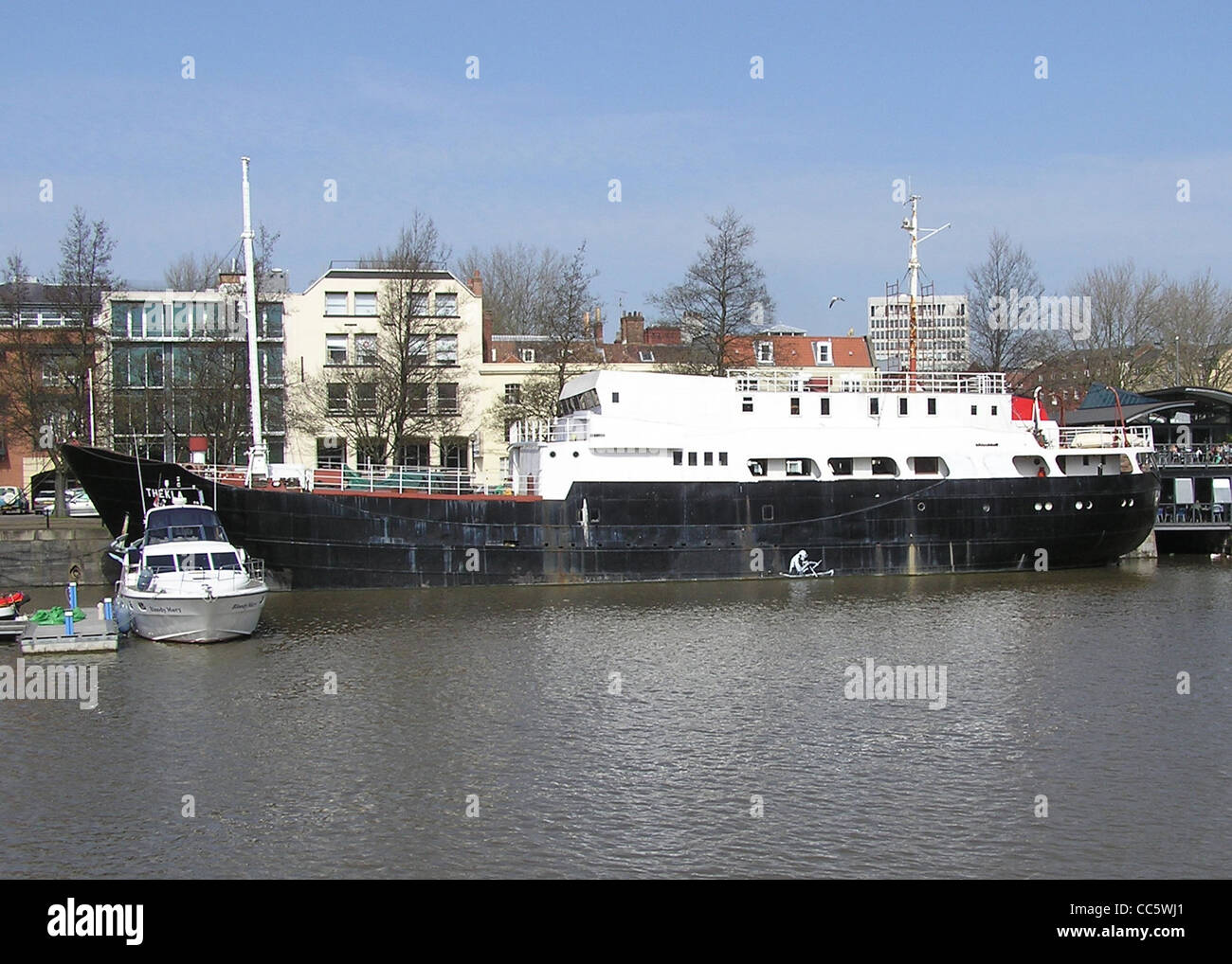 Thekla in 2005, moored at The Grove, East Mud Dock, Bristol, England. The Skeleton Rower graffiti is by Banksy. Stock Photo