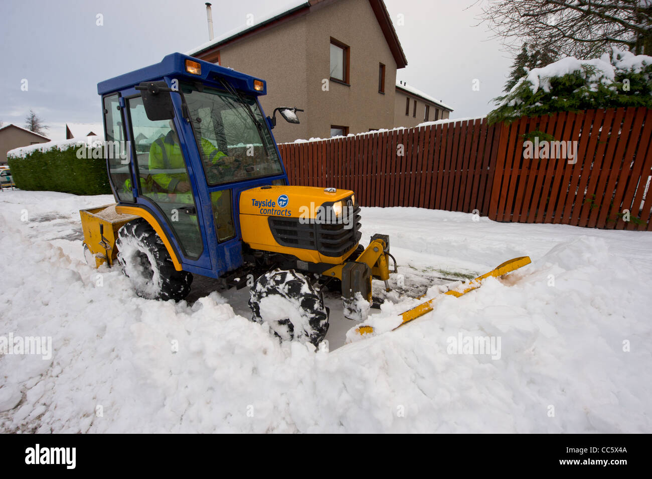 a council tractor clear the roads and pavements clear of snow Stock Photo