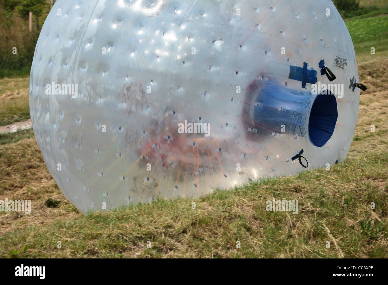 People enjoy Zorbing or Sphering on a hill in Dorset England. Stock Photo