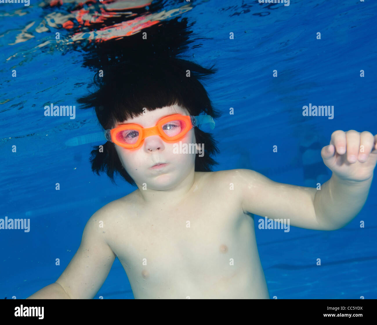 Three year old child swims underwater in a pool Stock Photo