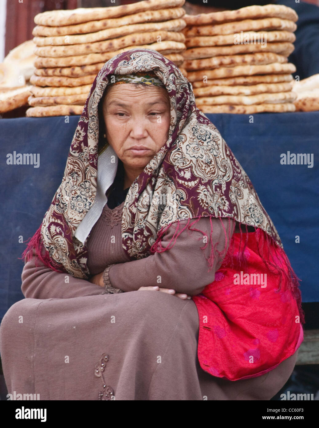 Uyghur woman sitting beside a stall, Xinjiang, China Stock Photo