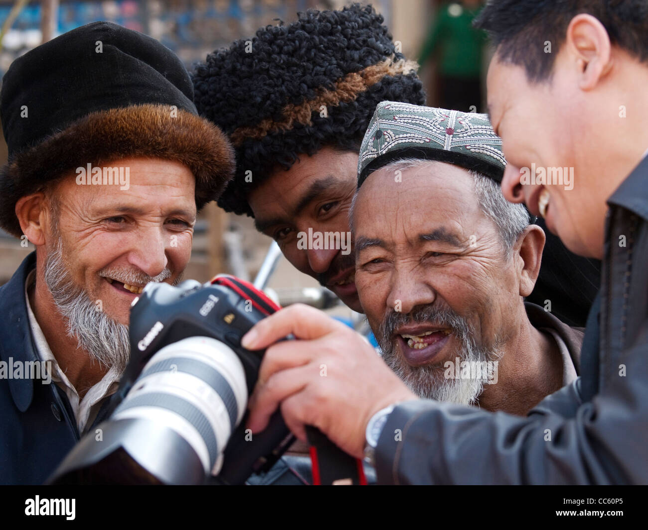 Photographer showing photos to Uyghur men, Xinjiang, China Stock Photo