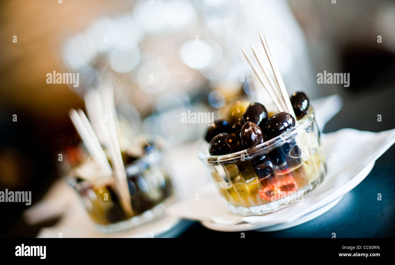 Selection of olives in a glass jar with cocktail sticks Stock Photo Alamy