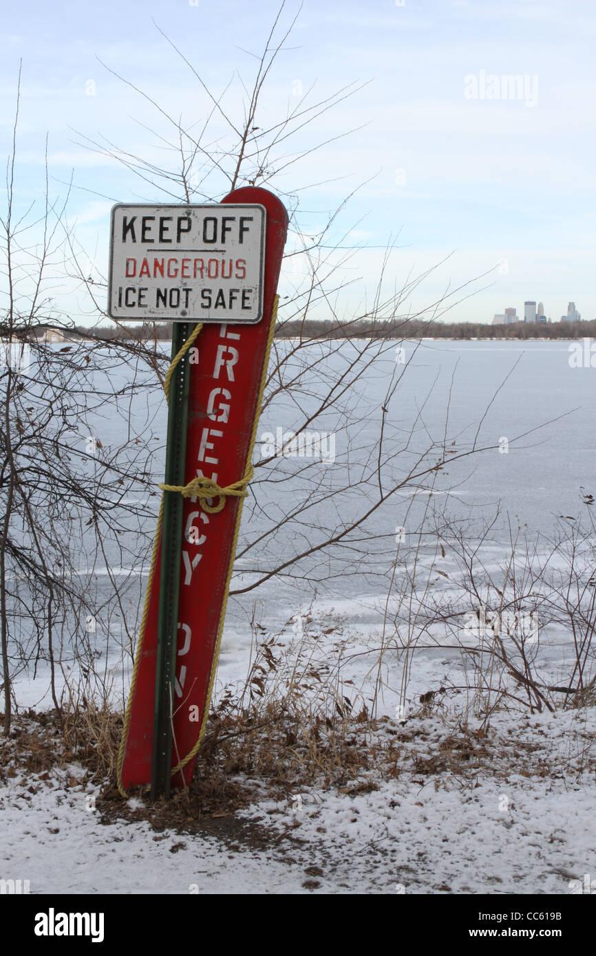 A sign warning of dangerous conditions on the ice on a lake in Minneapolis, Minnesota. Stock Photo