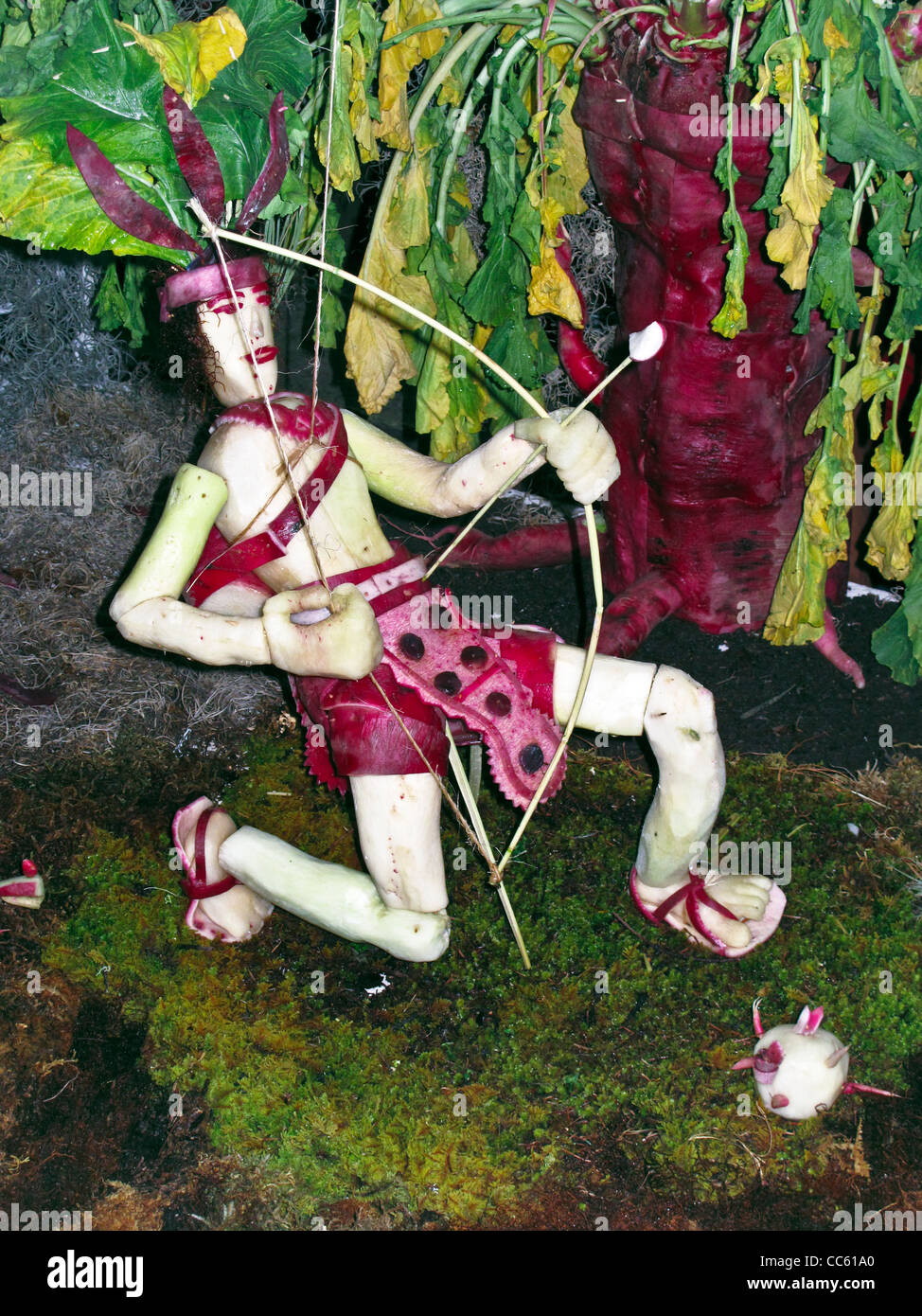 delightful folk art sculpture carved from radishes of kneeling archer drawing bowstring for Noche de Rabanos festival in Oaxaca Stock Photo