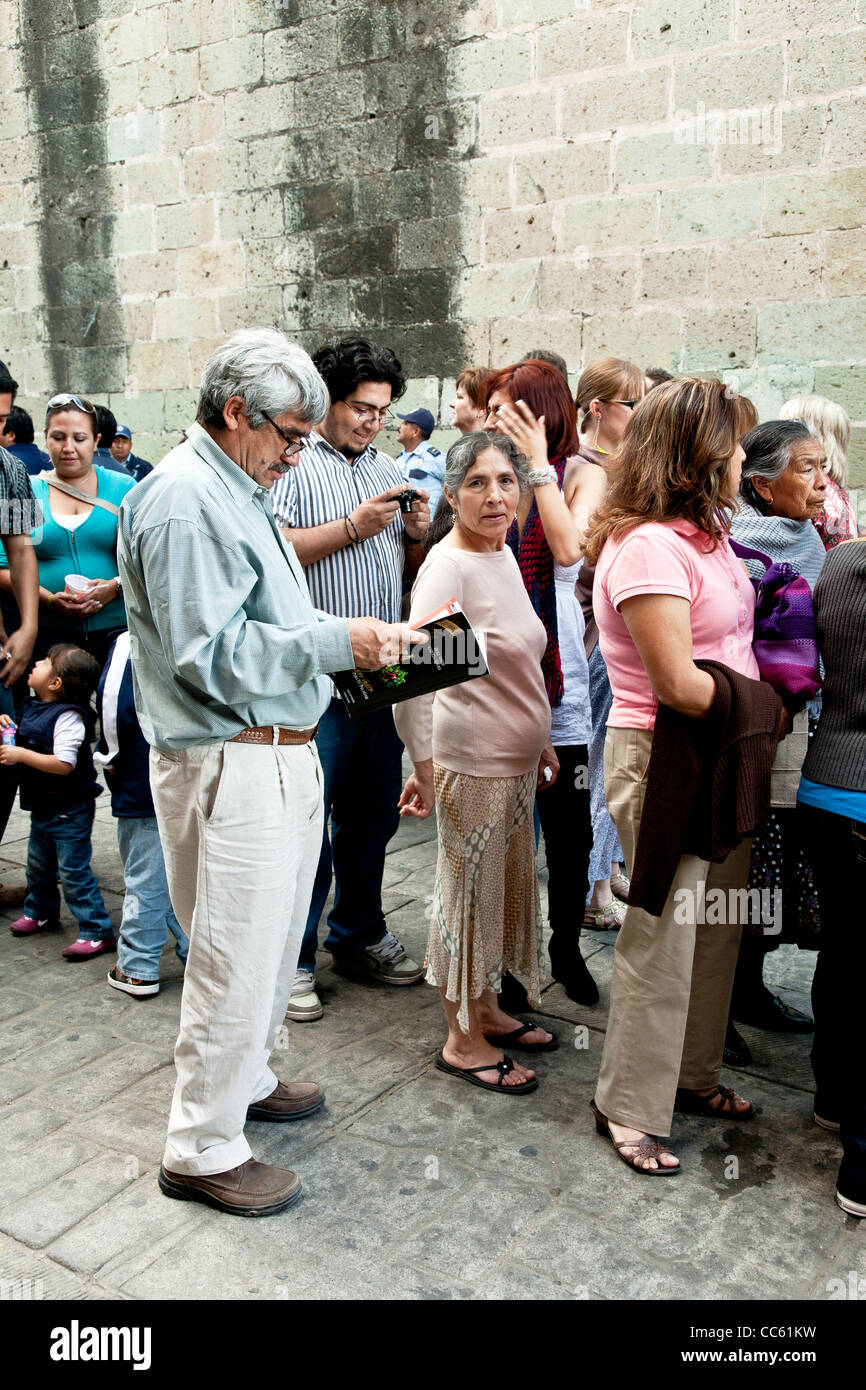 diverse group of Mexican people in line to view folk art sculpture carved from radishes for Noche de Rabanos festival in Oaxaca Stock Photo