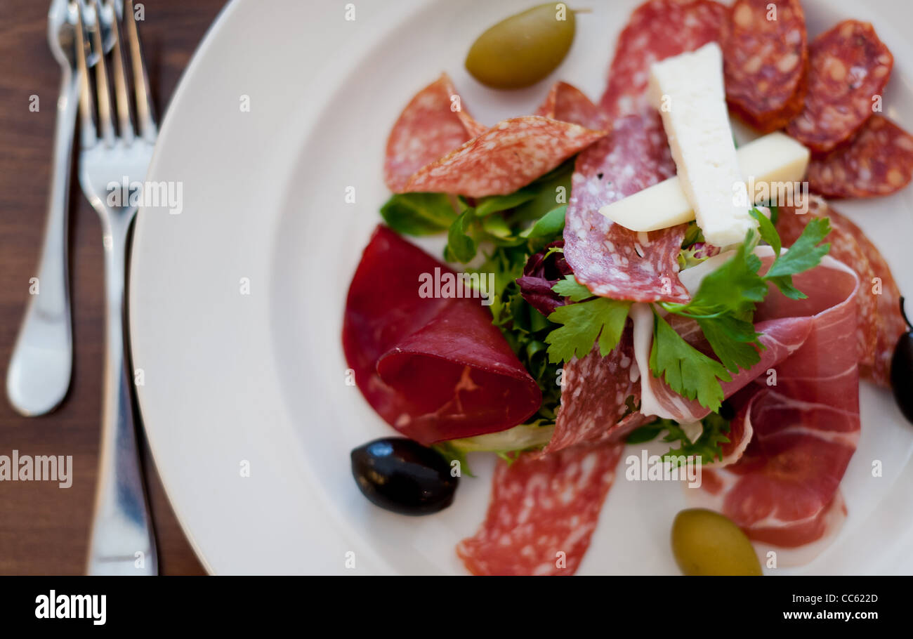 Italian ham, cheese and olives with cutlery Stock Photo