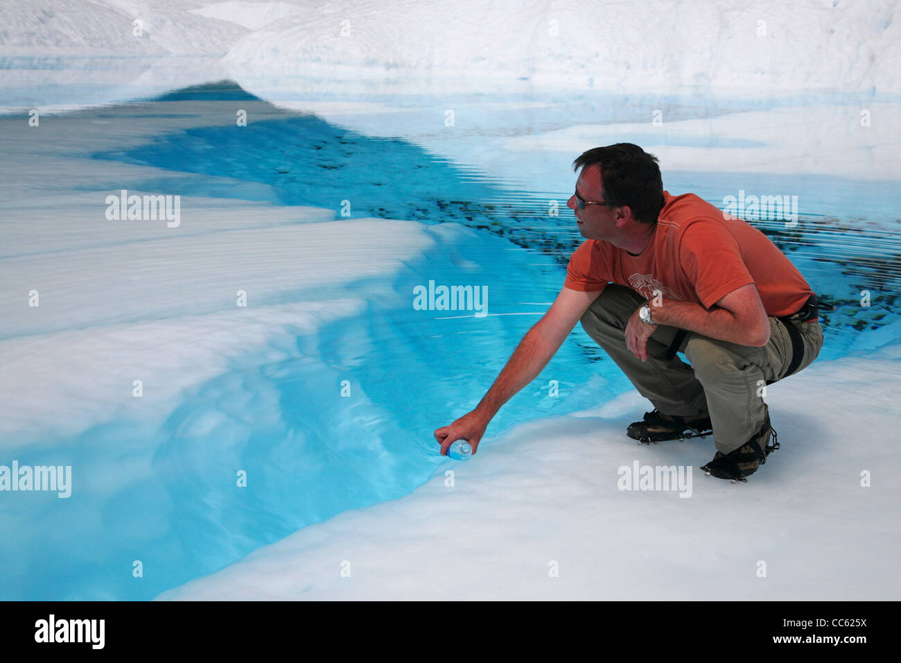 Tourist filling bottle with glacial water of the Perito Moreno glacier in the Los Glaciares National Park, Patagonia, Argentina Stock Photo