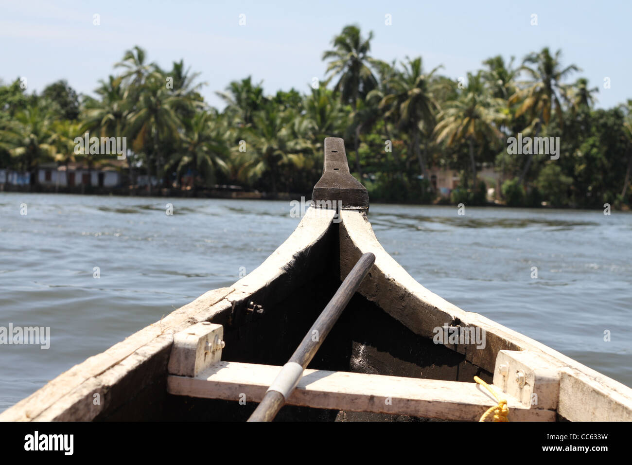 A passenger view from the front of a canoe on a beautiful backwater cruise in Kerala Southern India looking out to a palm bank. Stock Photo