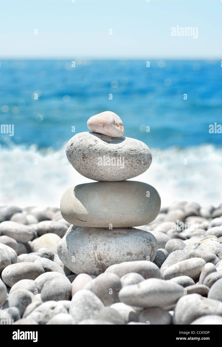 Stack sea pebbles against the blue sea Stock Photo