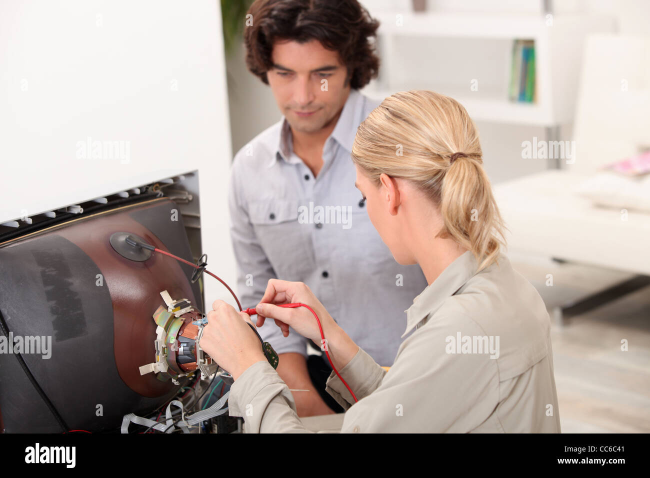 Couple repairing old television Stock Photo Alamy