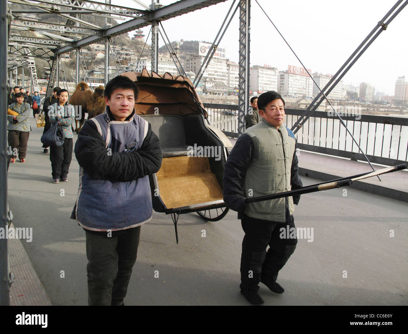 People wearing traditional costume walking on Yellow River Iron Bridge, Lanzhou, Gansu , China Stock Photo