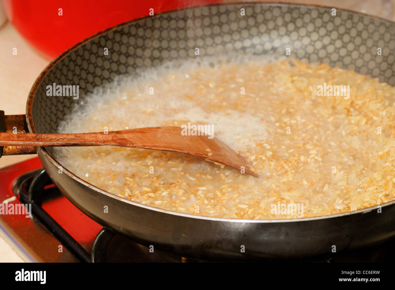 rice on frying pan, skillet, wood spoon Stock Photo Alamy