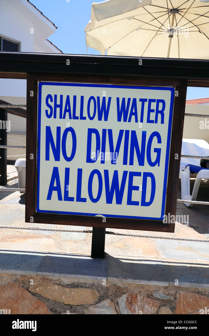 Warning sign near a swiming pool: 'Shallow water. No diving allowed'. Snapshot-style photograph. Stock Photo