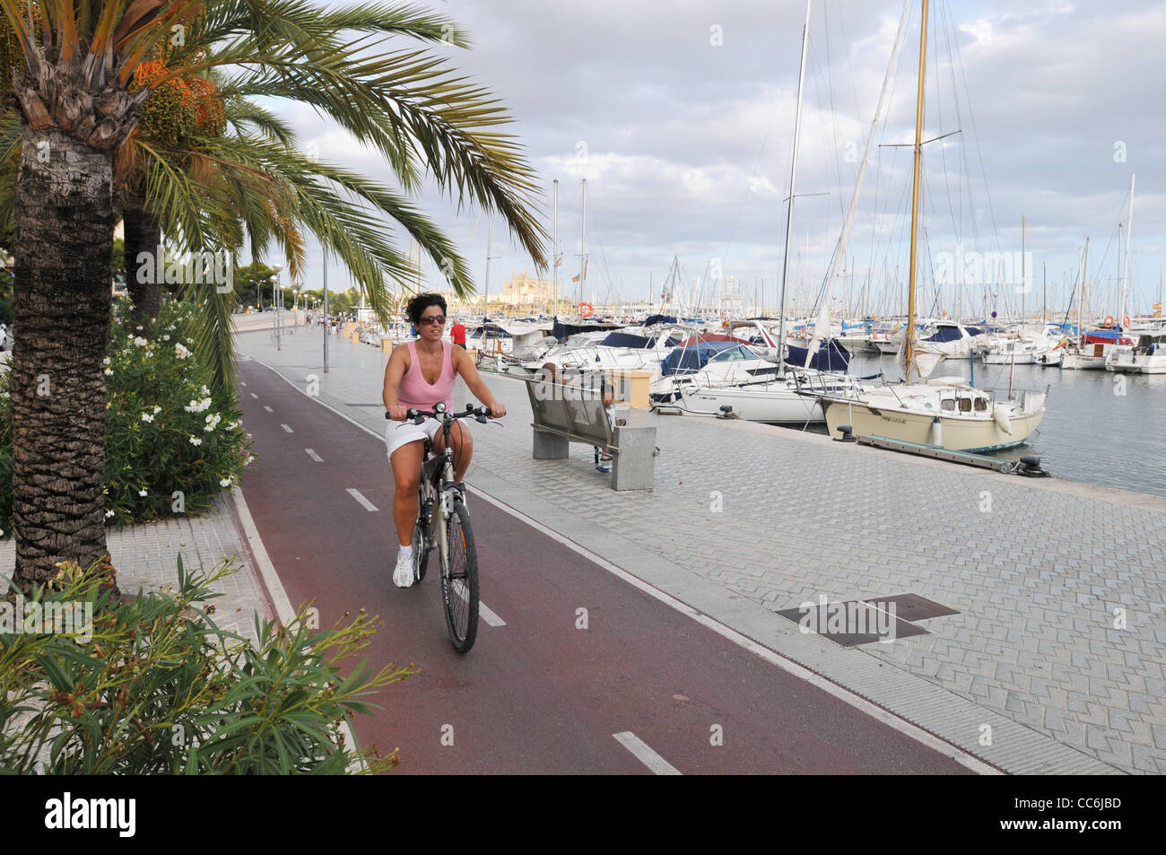 A woman cycles along the cycle lane in Palma, Mallorca Stock Photo