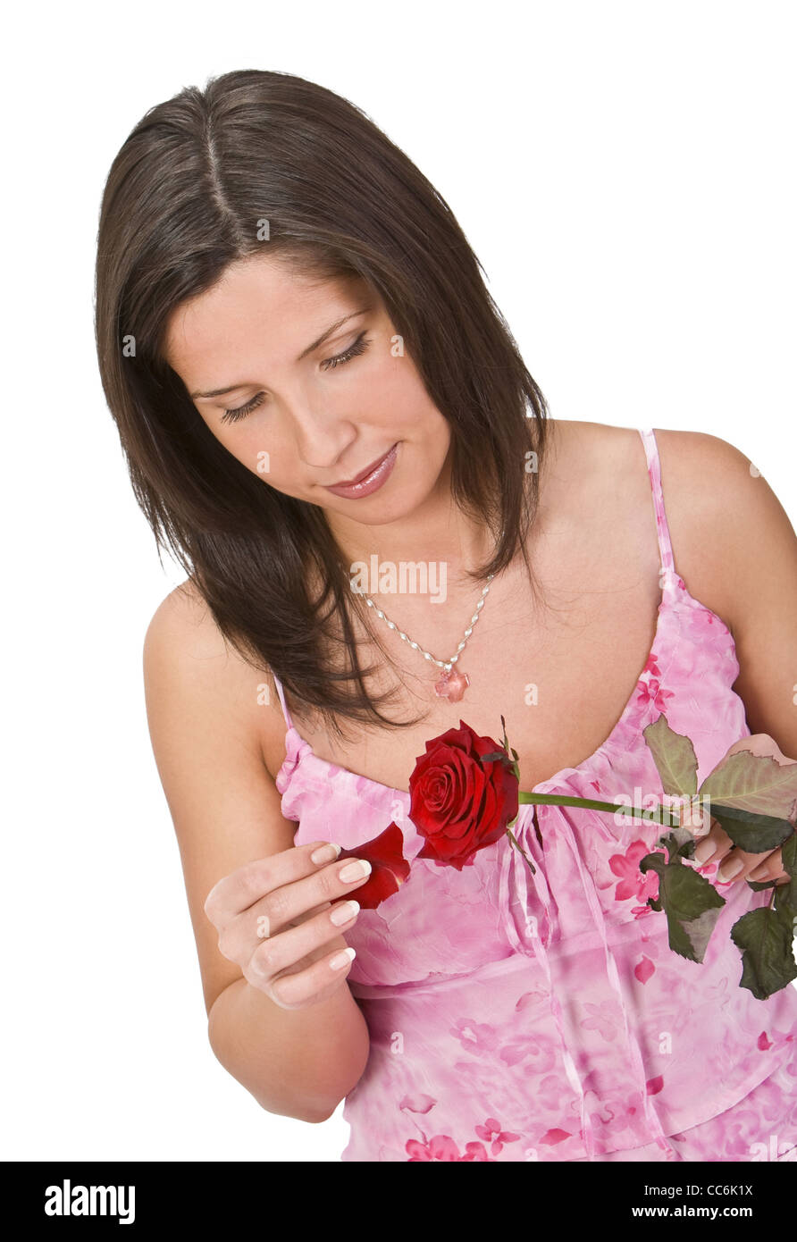 Romantic girl plucking off rose petals while counting to decide on the classical feminine matter: He loves me vs he loves me not Stock Photo