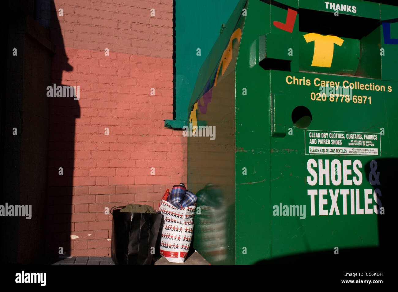 Bags of second-hand clothing left near a charity shop receptacle in a Stock Photo: 41943597 - Alamy