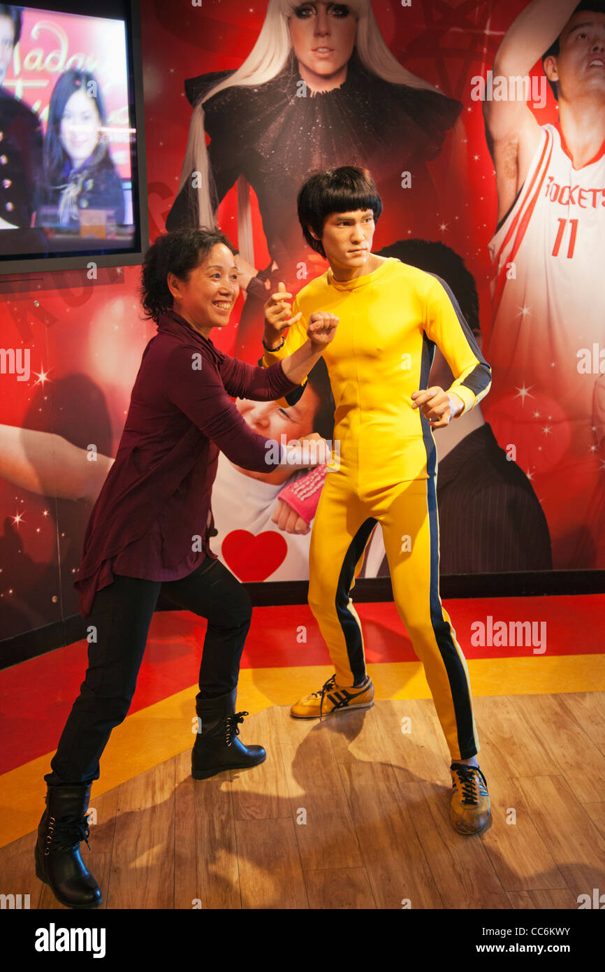 China, Hong Kong, The Peak Tower, Madame Tussauds, Tourist Posing with Statue of Bruce Lee Stock Photo