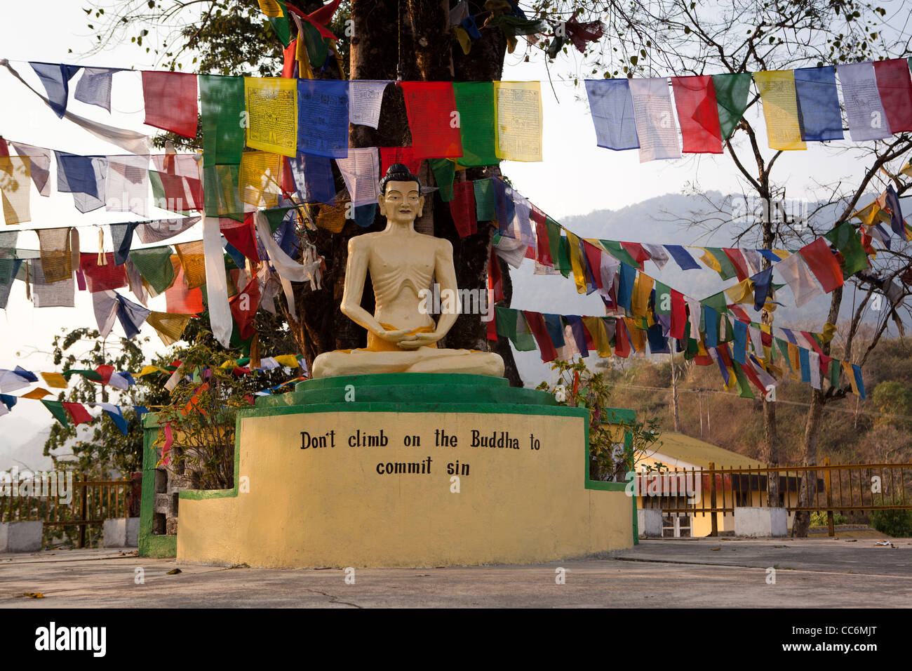 India, Arunachal Pradesh, Itanagar, Buddha Vihar Tibetan Buddhist Temple starving Buddha below prayer flags Stock Photo