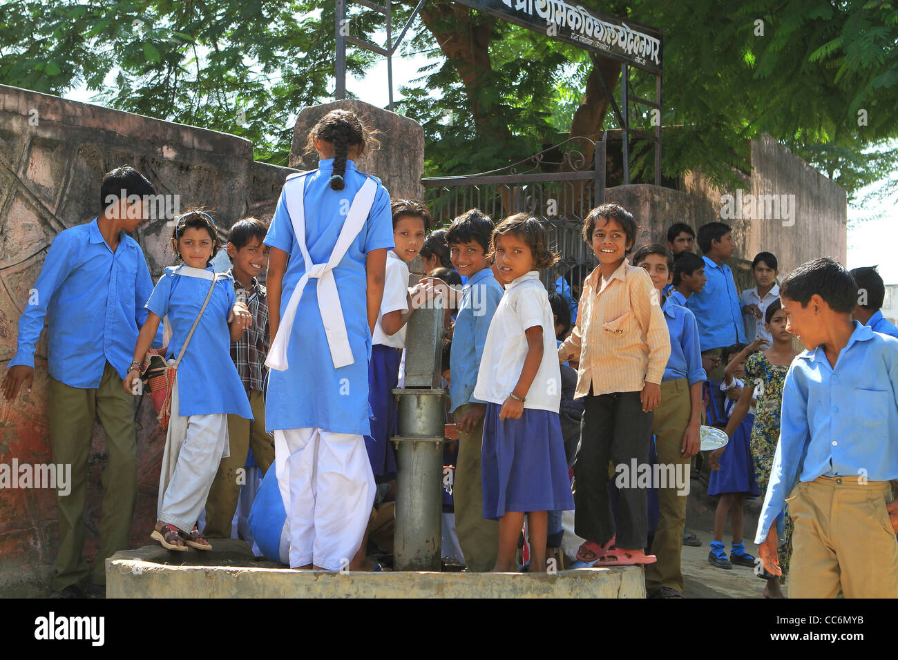 Indian schoolchildren on a break at the village well. Rajasthan Stock Photo