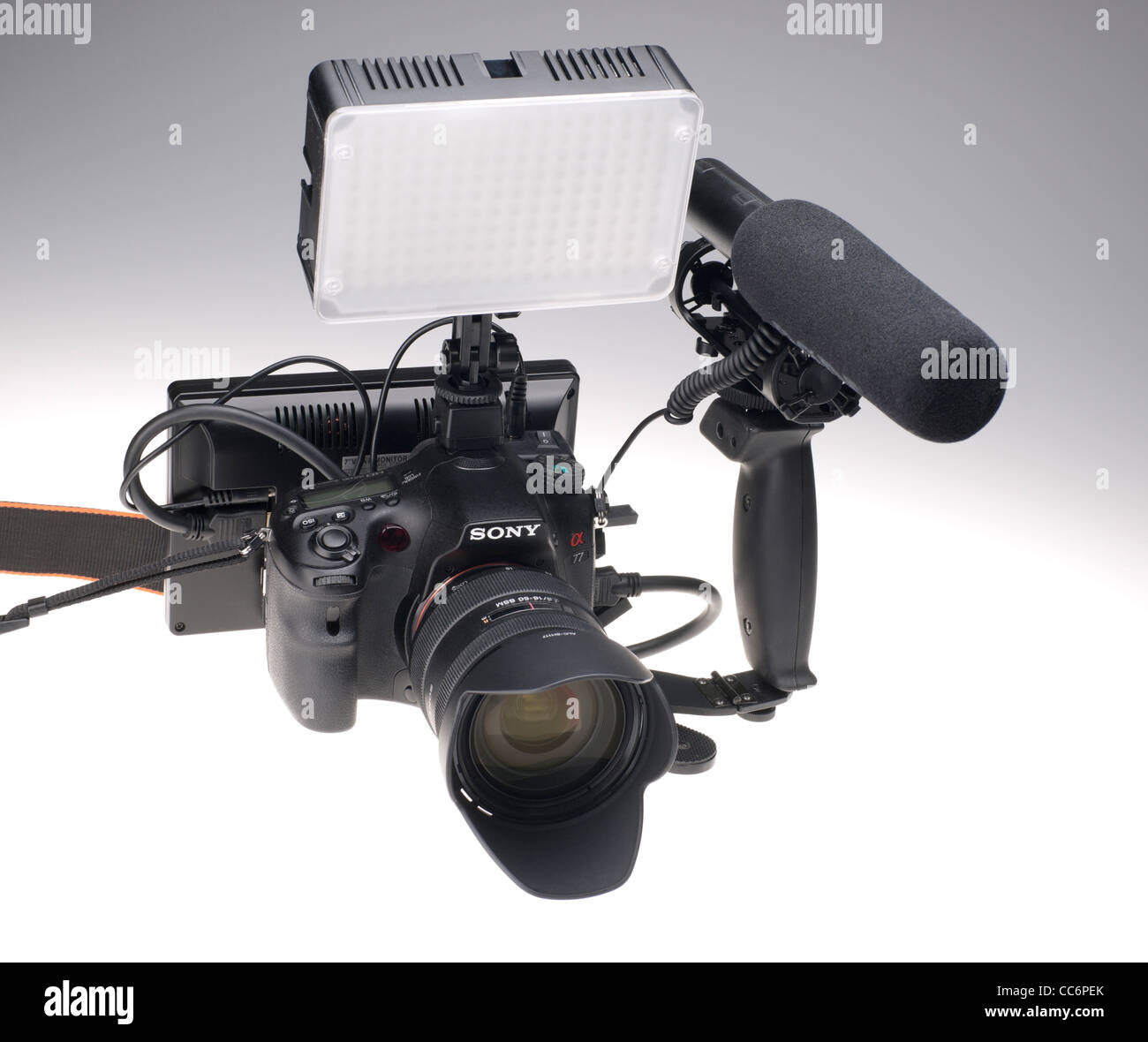Sony Alpha 77 HD video rig with LED camera top light, Røde VideoMic microphone, and 7 inch large HD monitor for framing shots. Stock Photo