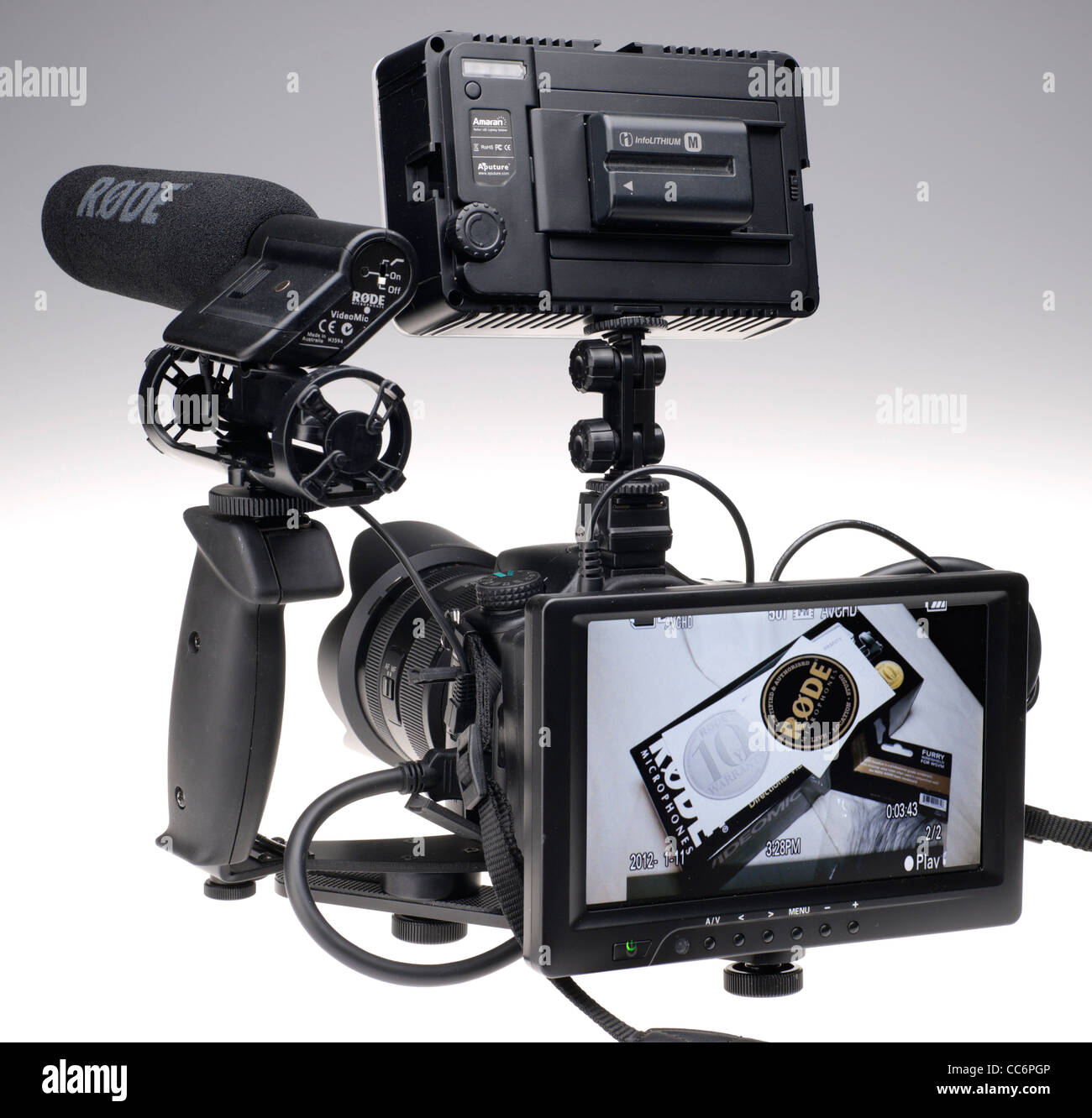 Sony Alpha 77 HD video rig with LED camera top light, Røde VideoMic microphone, and 7 inch large HD monitor for framing shots. Stock Photo