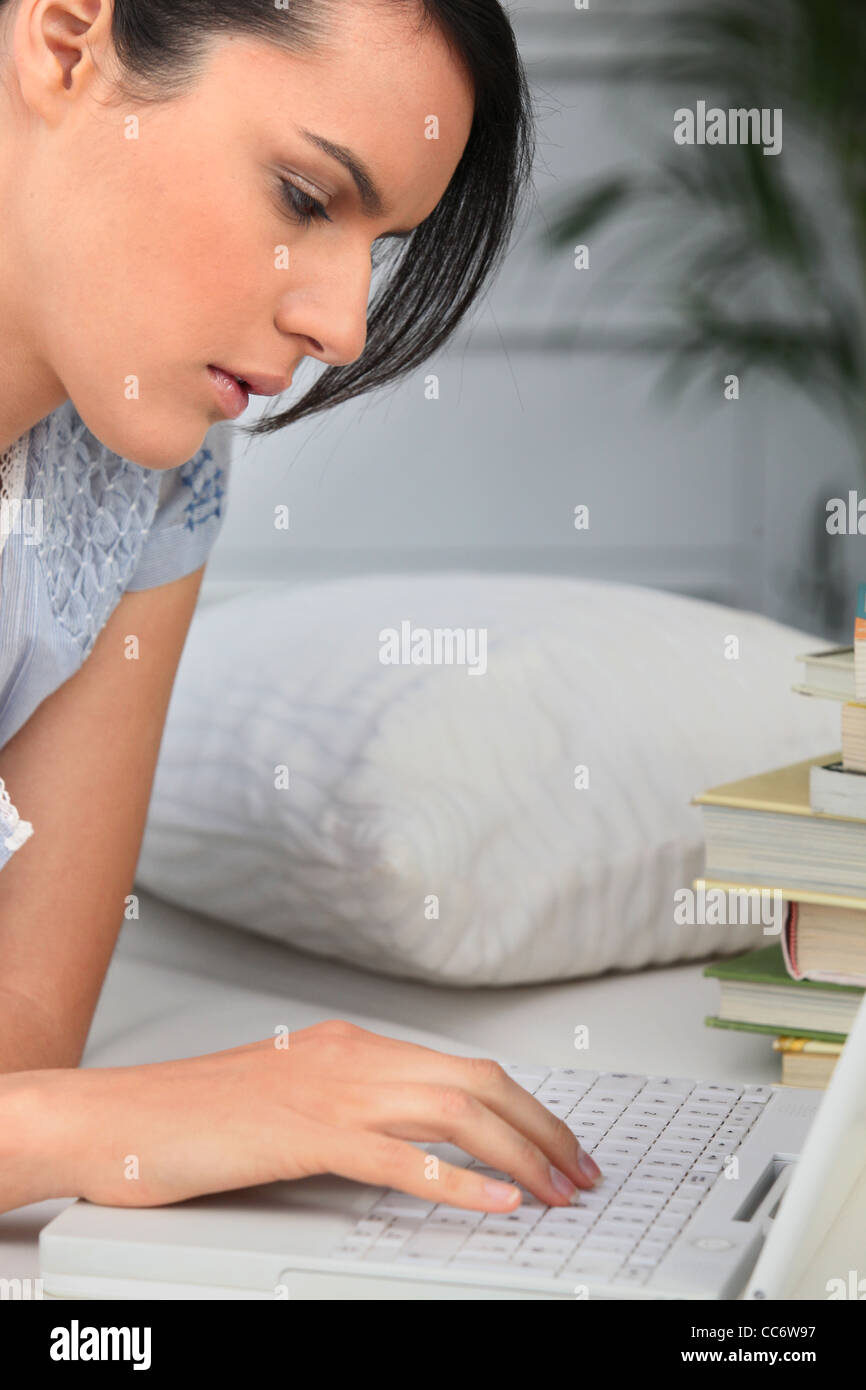 Student with a pile of books and a laptop computer Stock Photo - Alamy
