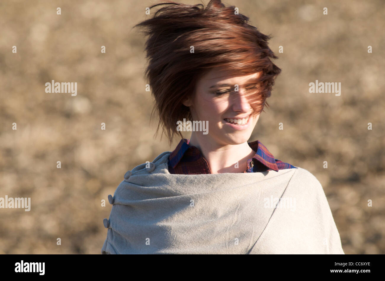 Young woman in a field with hair in the wind. Stock Photo