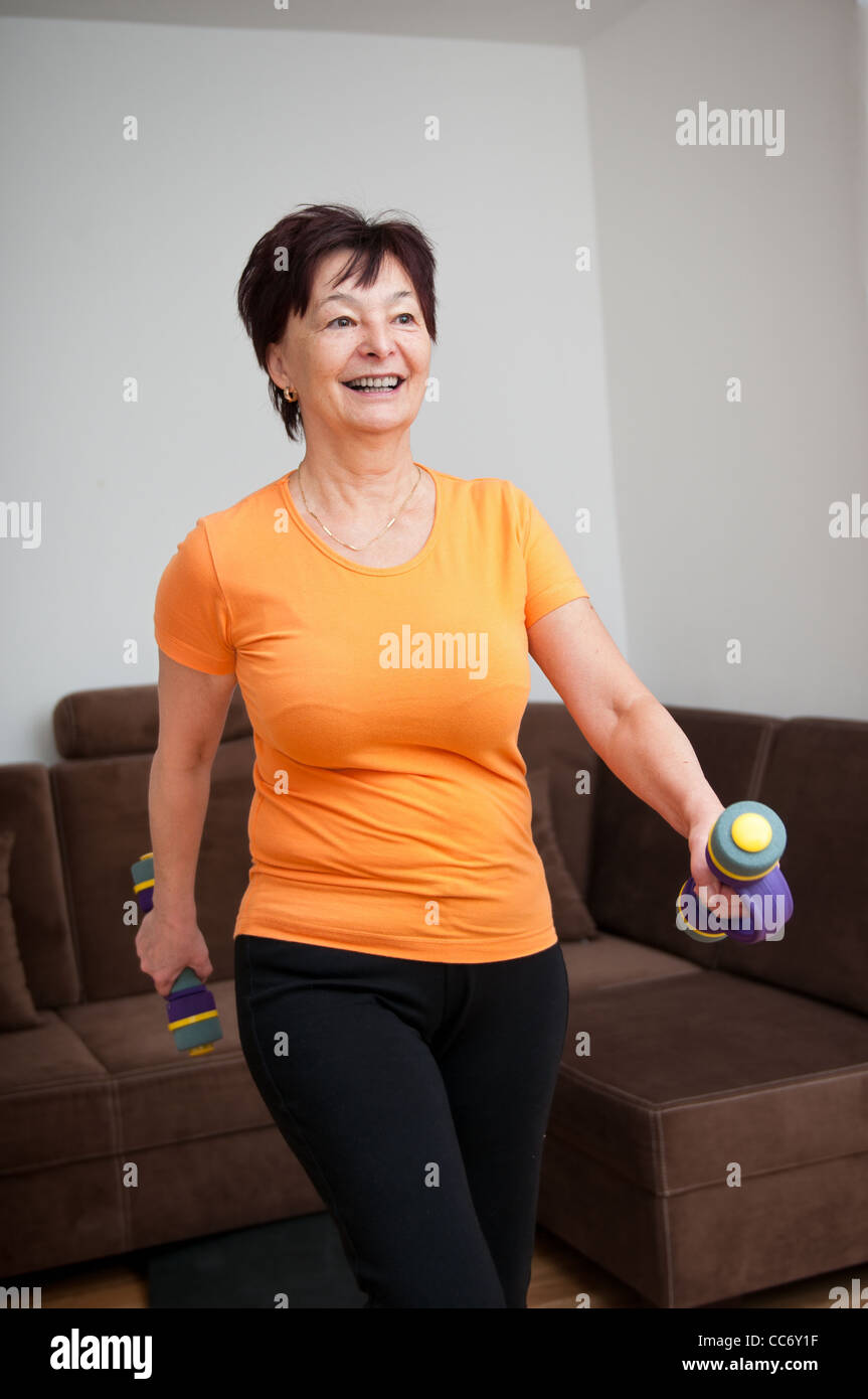 Senior woman exercising with barbells Stock Photo