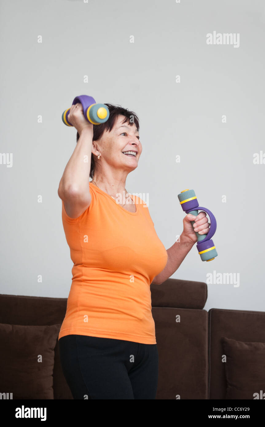 Senior woman exercising with barbells Stock Photo