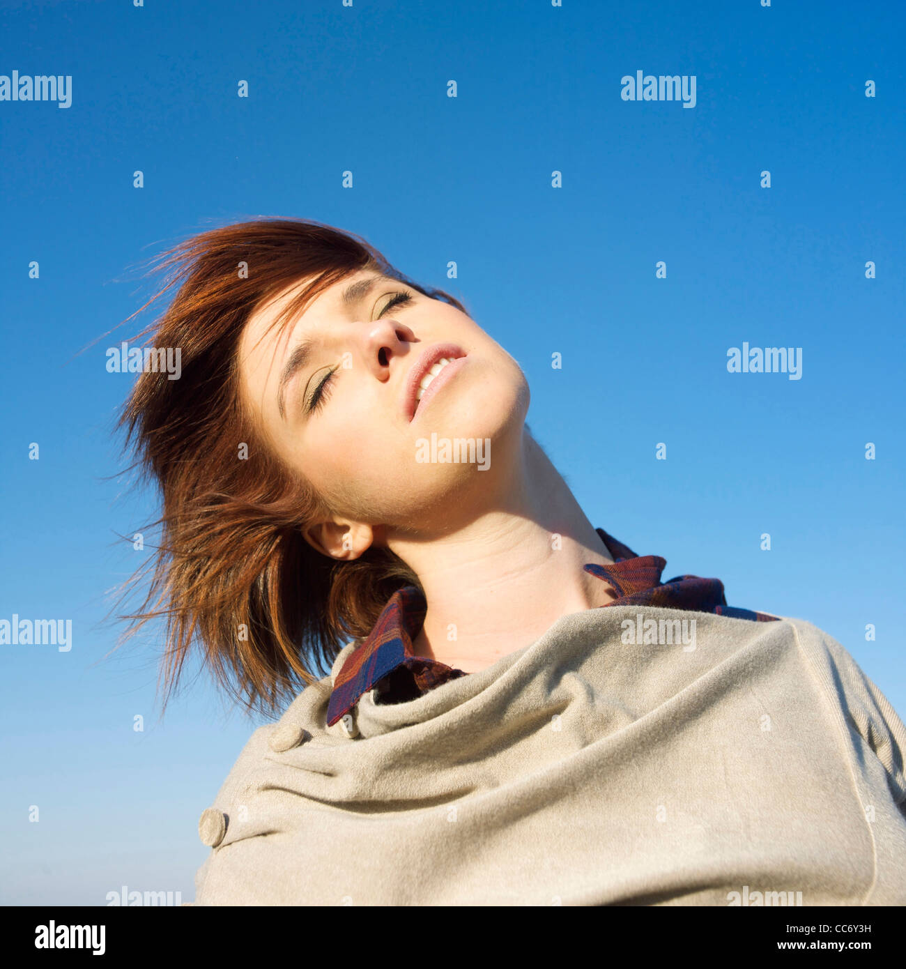 Young woman with hair in the wind looking up. Stock Photo