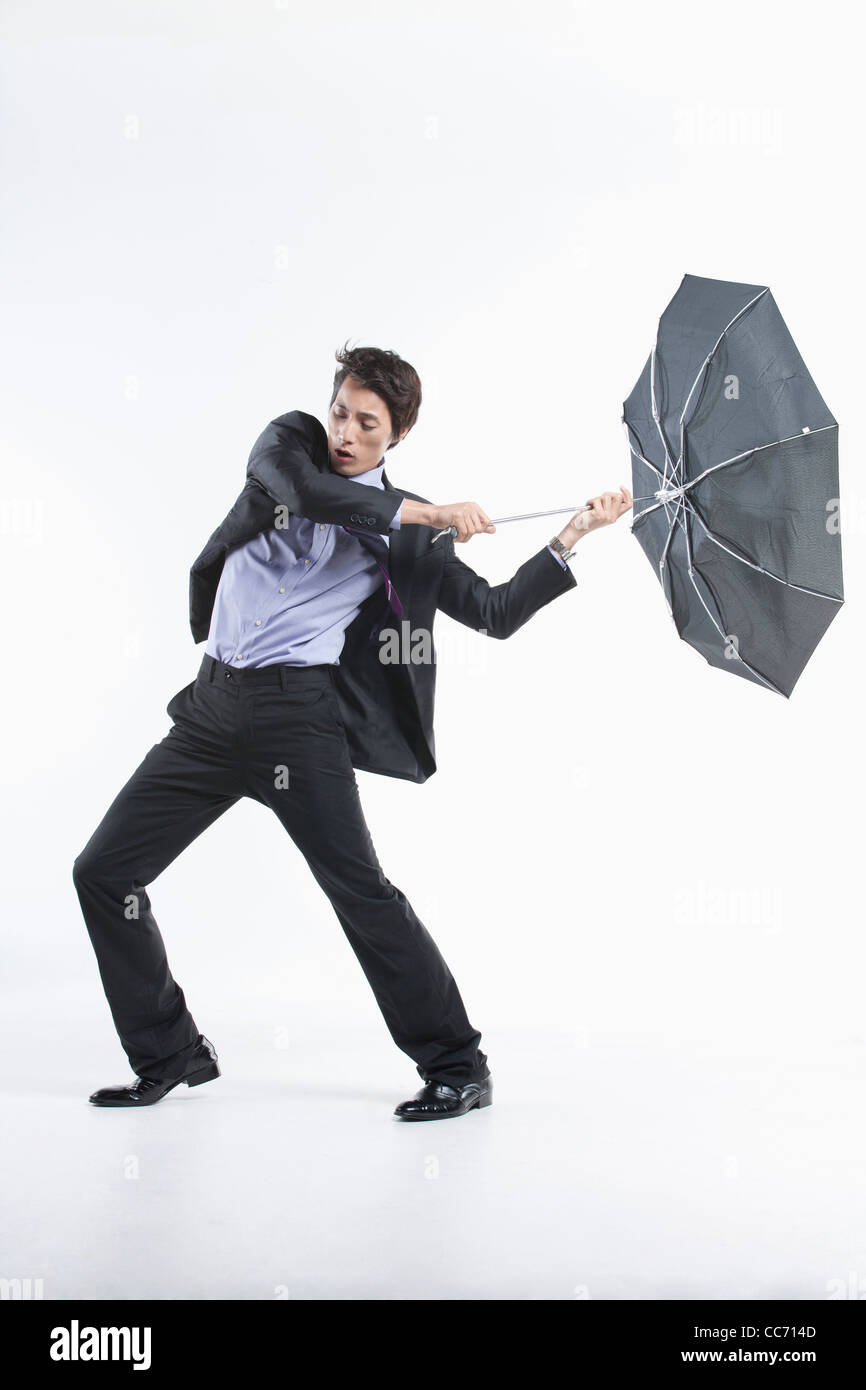 A man hit by the strong wind with an umbrella inside out Stock Photo