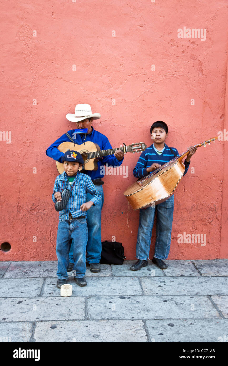 Mexican father parent & two fine looking young sons child children working as street musicians on Macedonio Alcala Oaxaca Mexico Stock Photo