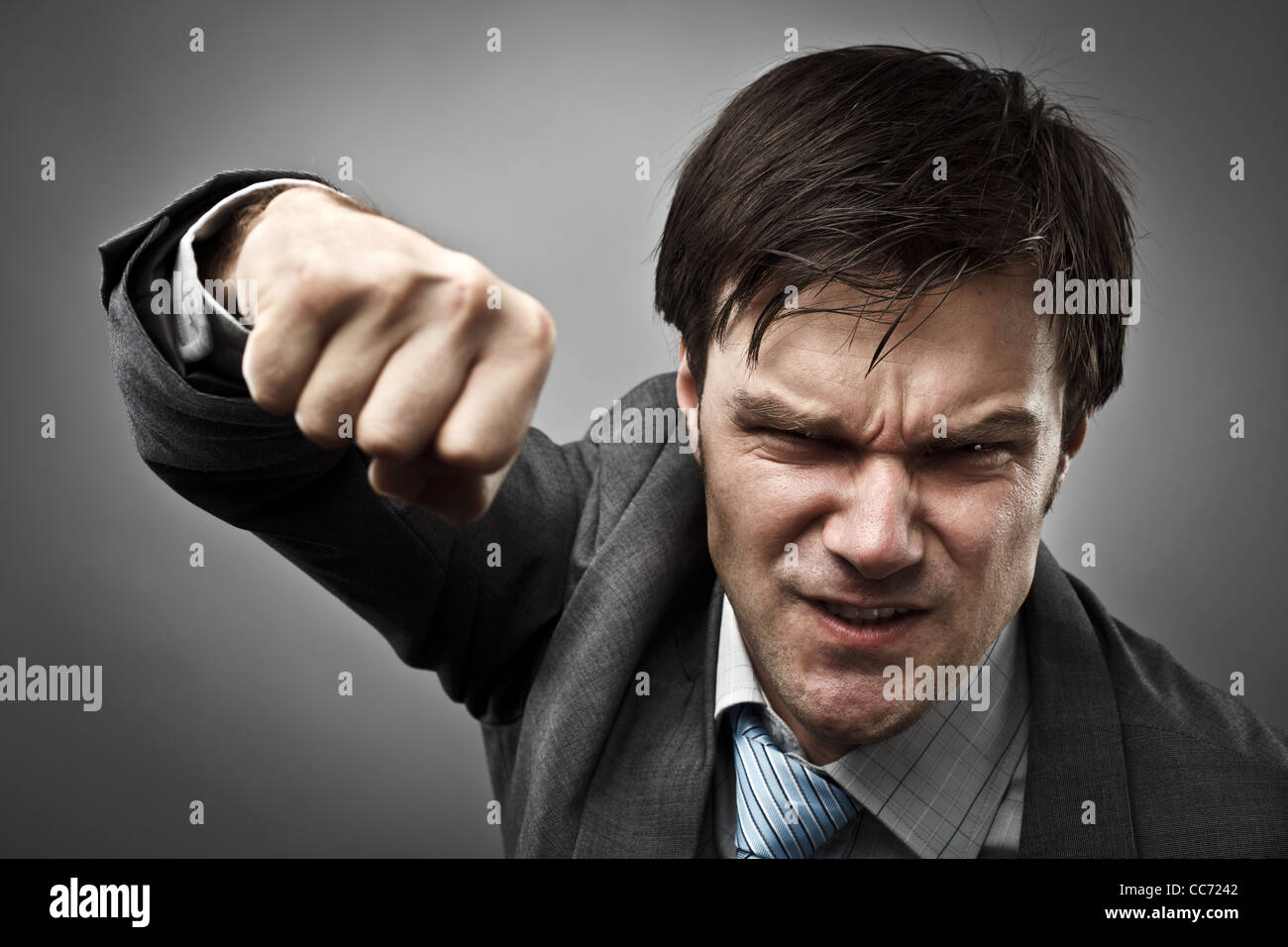 Studio portrait of an aggressive businessman punching Stock Photo Alamy