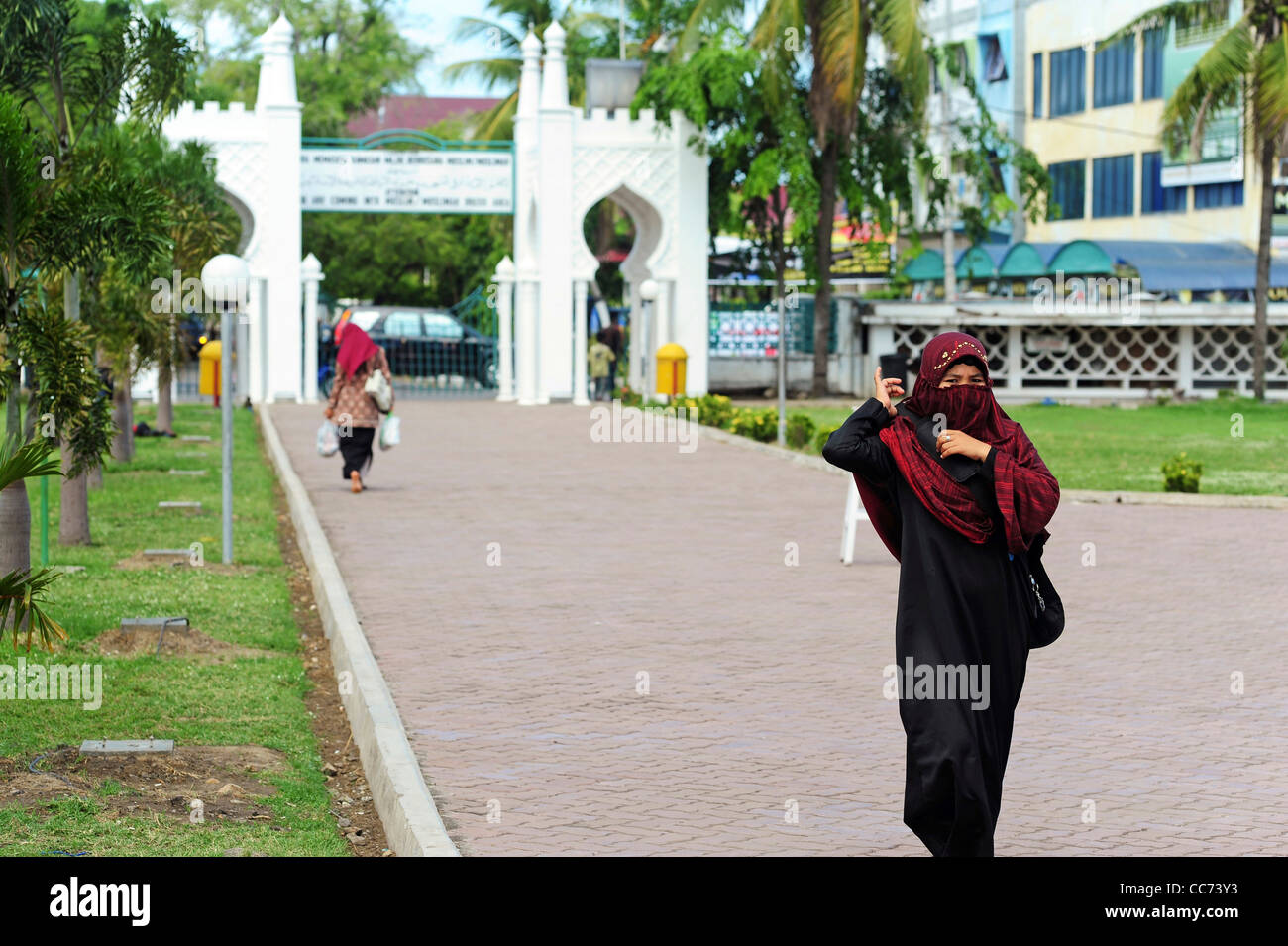Indonesia, Sumatra, Banda Aceh, veiled woman walking to Baiturrahman Grand Mosque (Mesjid Raya Baiturrahman) Stock Photo
