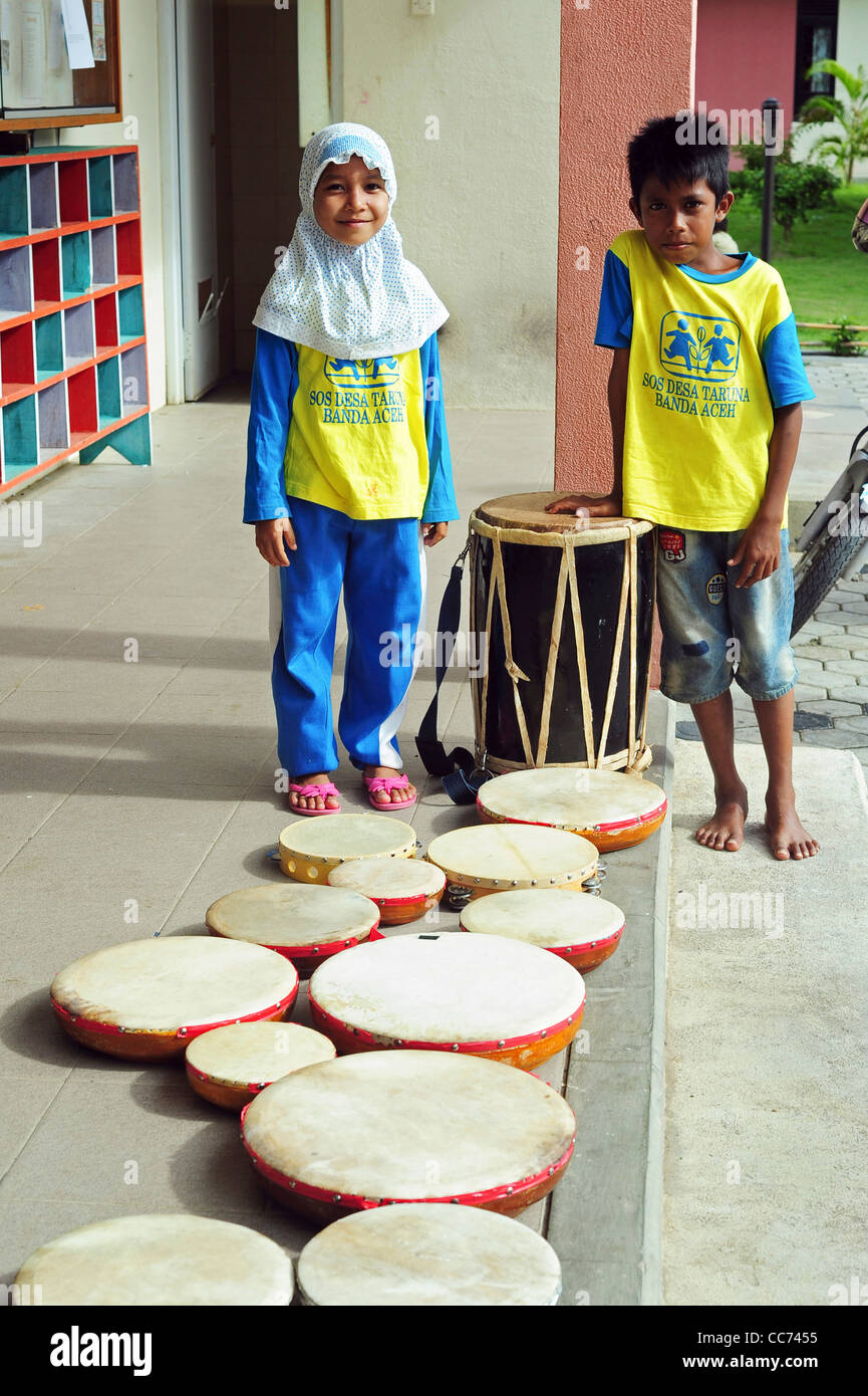 Indonesia, Sumatra, Banda Aceh, boy and girl playing the drums Stock Photo