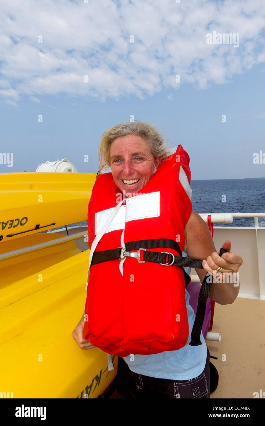 Woman passenger during life boat drill aboard cruise yacht in Hawaii, USA. Stock Photo