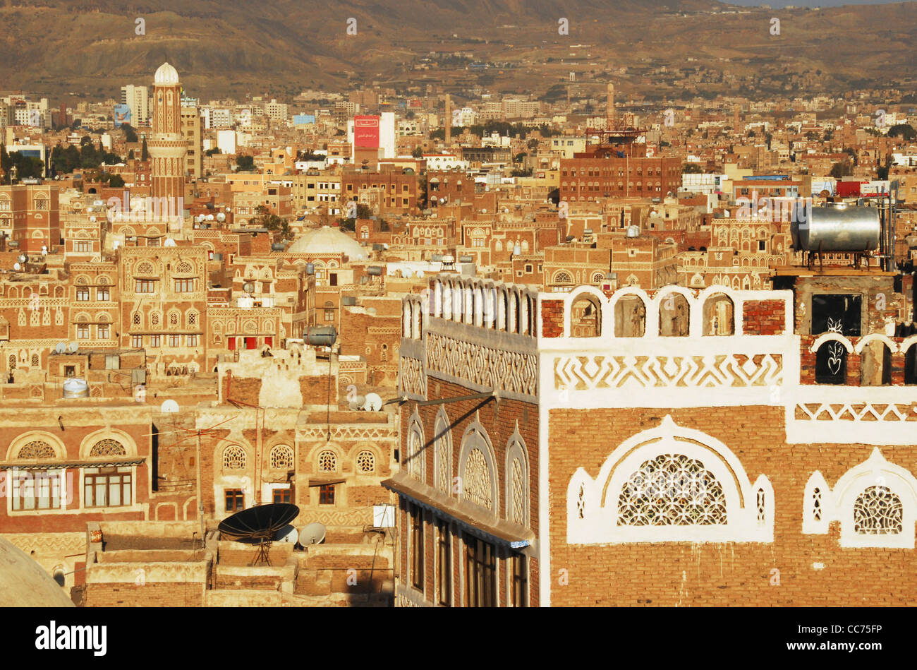 Yemen, Sanaa, cityscape with buildings and decorative white carvings, mountains in the background Stock Photo
