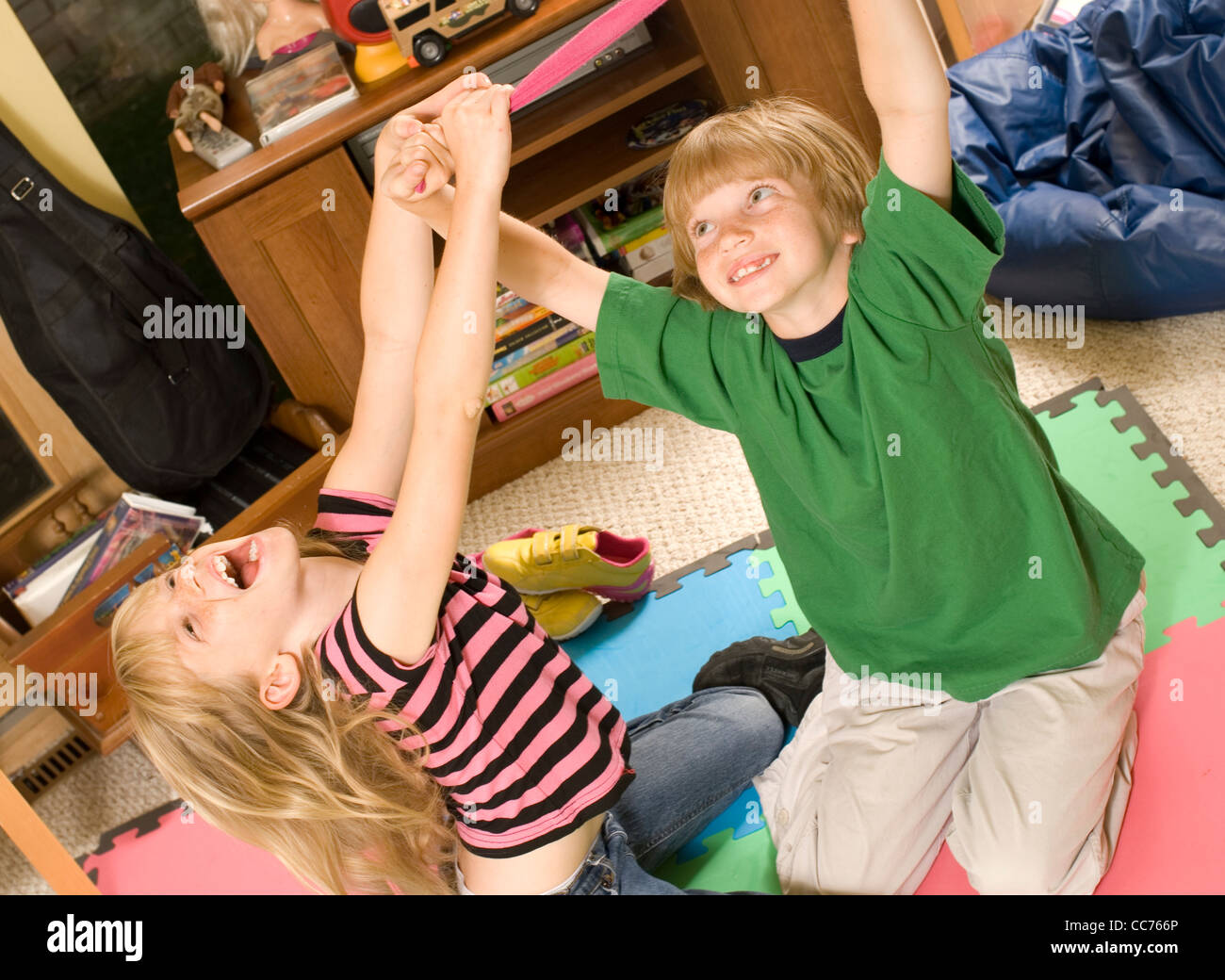 Twins wrestling and tickling in their playroom Stock Photo