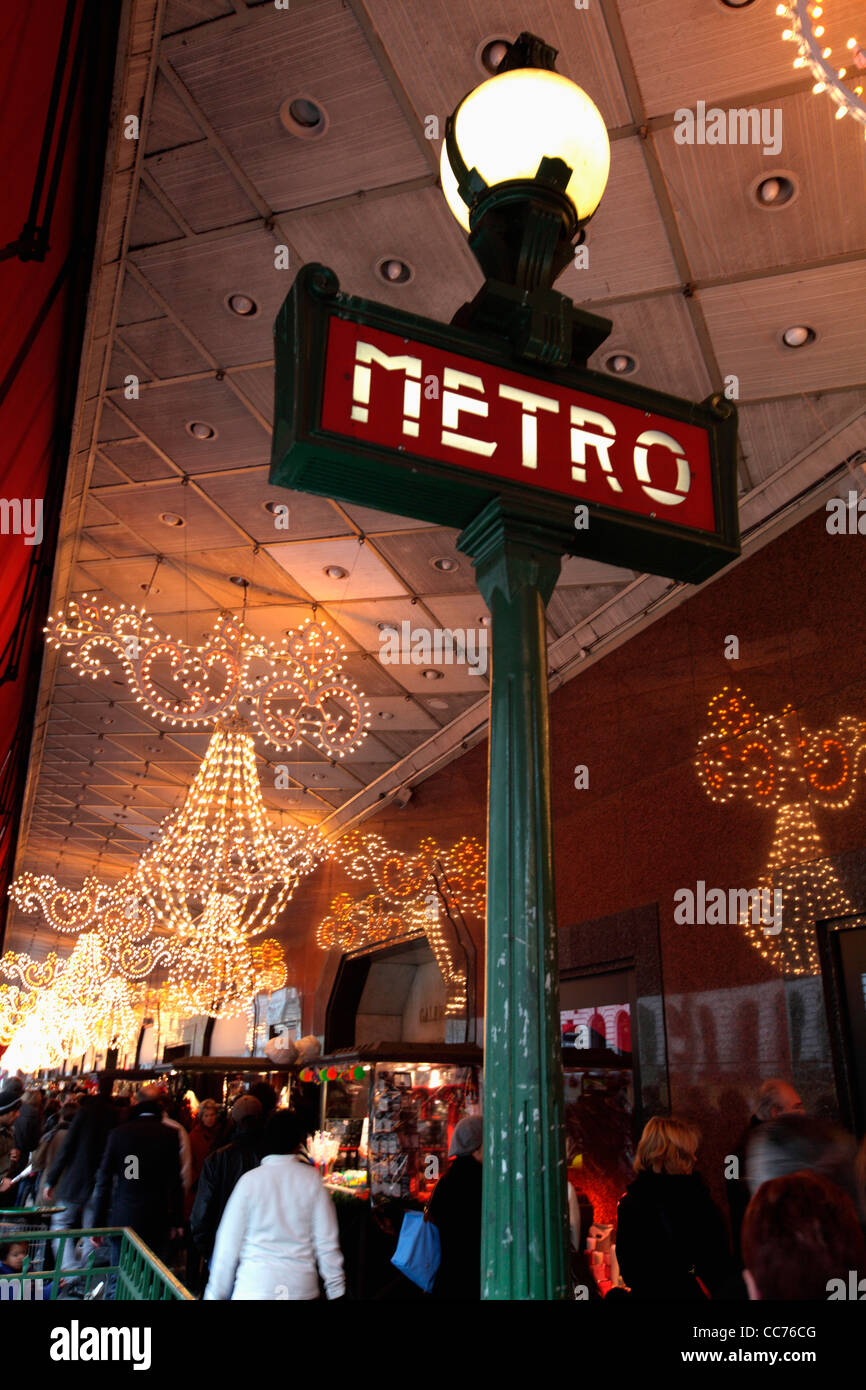 France, Paris, The sign of a Metro station with the Christmas lights decoration of Galeries Lafayette department store Stock Photo