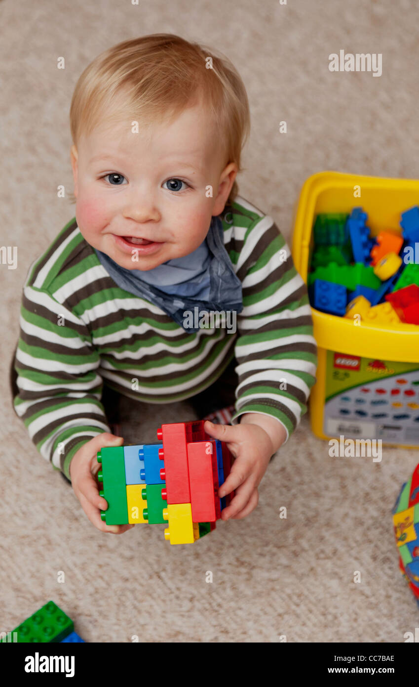 Young boy (1 year) playing with colourful lego bricks Stock Photo