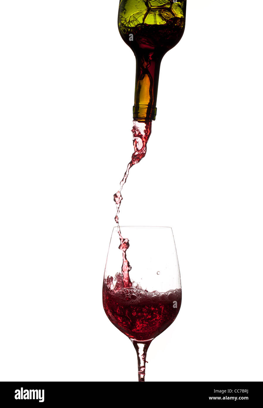Red wine being poured directly from bottle into a large goblet Stock Photo