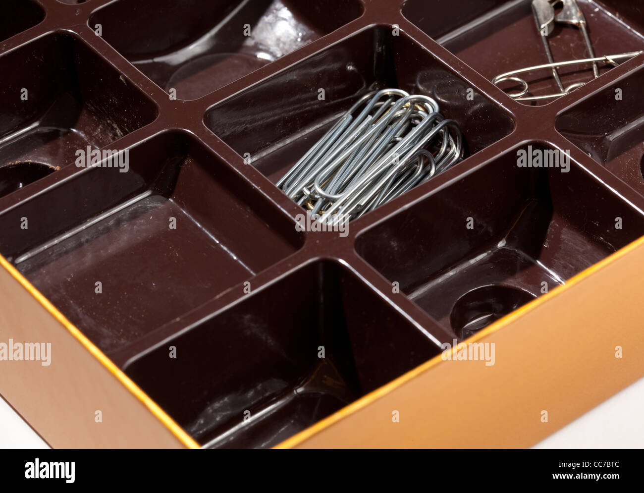 Home organizer for paper clips and staples from old chocolate liner in