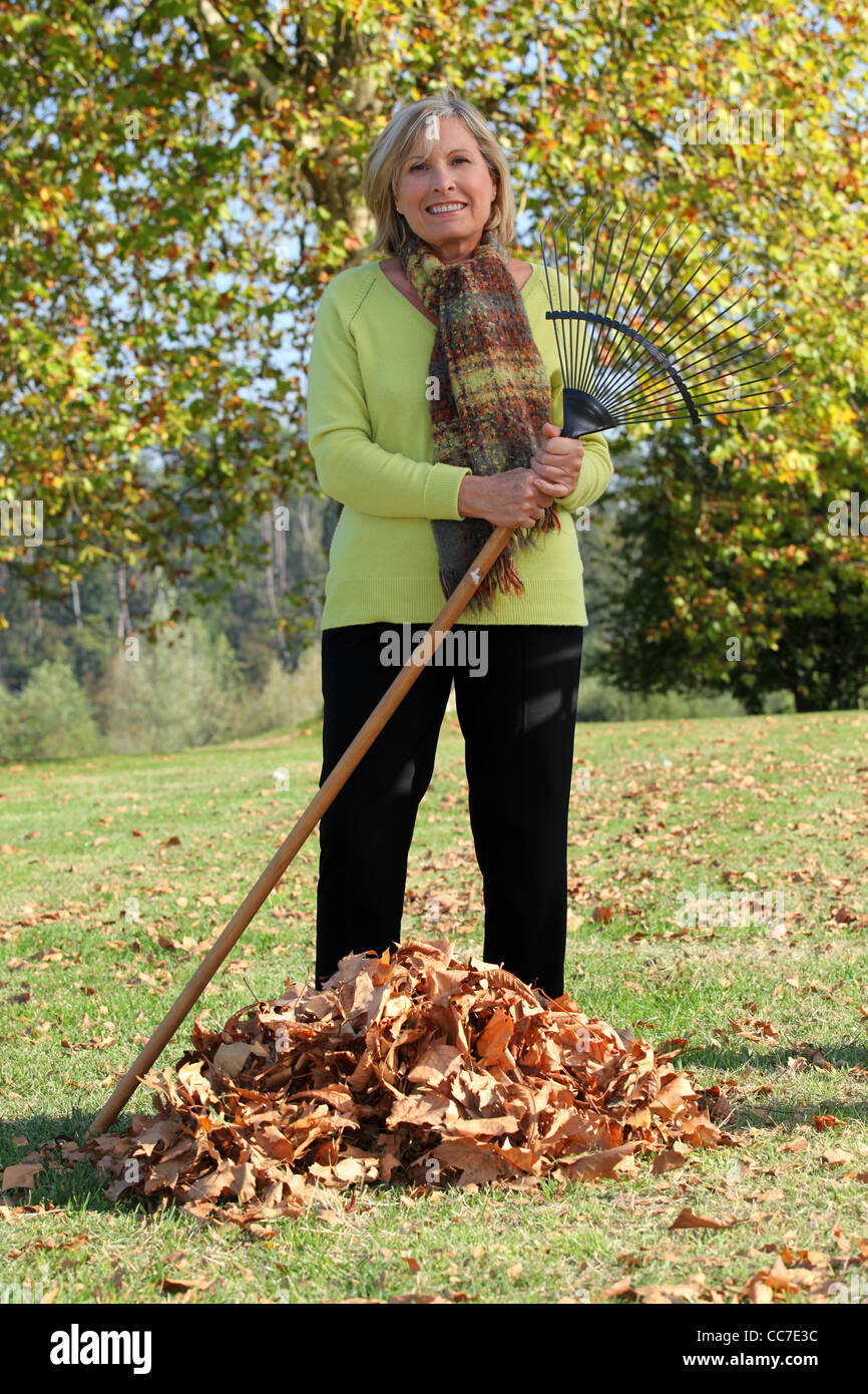 Mature woman raking leaves hi-res stock photography and images - Alamy