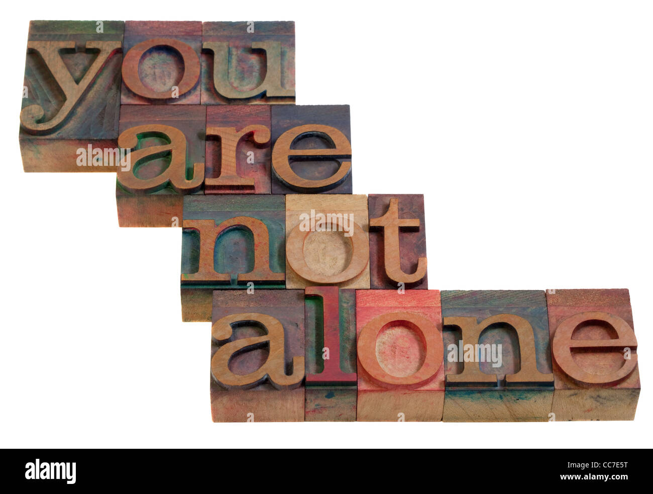 you are not alone - words in vintage wooden letterpress printing blocks, stained by color inks, isolated on white Stock Photo