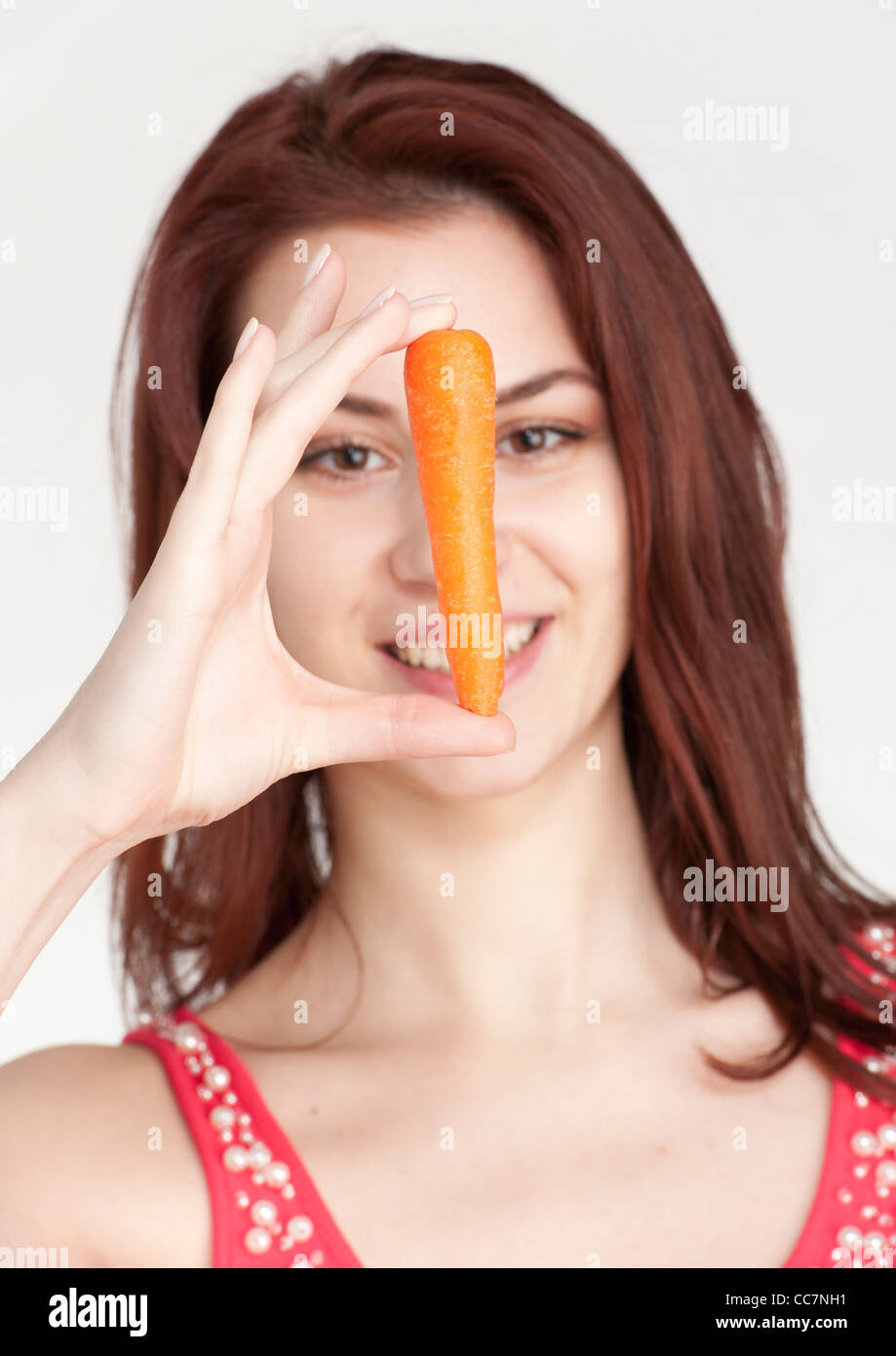 Young woman holding an organic carrot Stock Photo