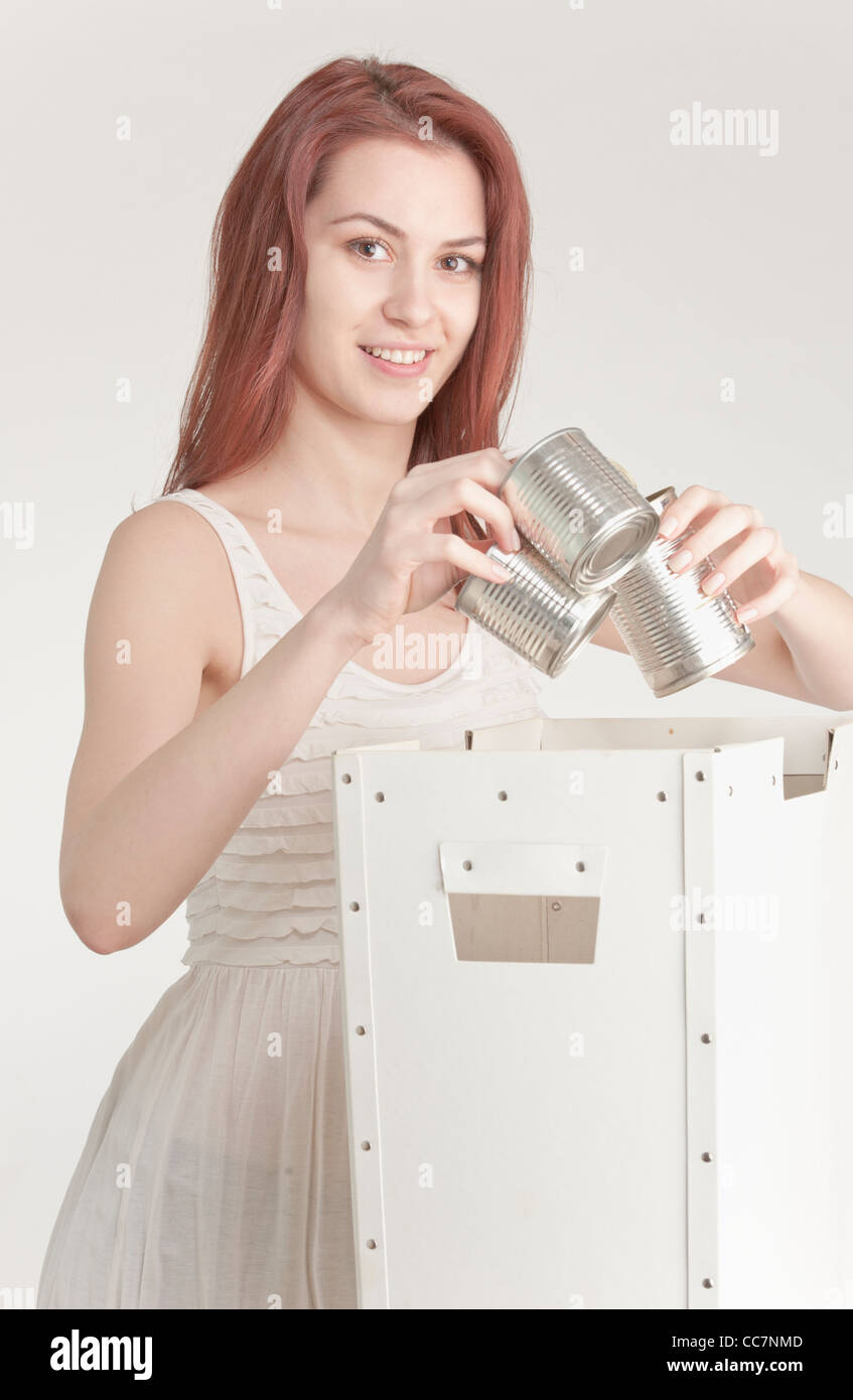 Young woman recycling tin cans Stock Photo
