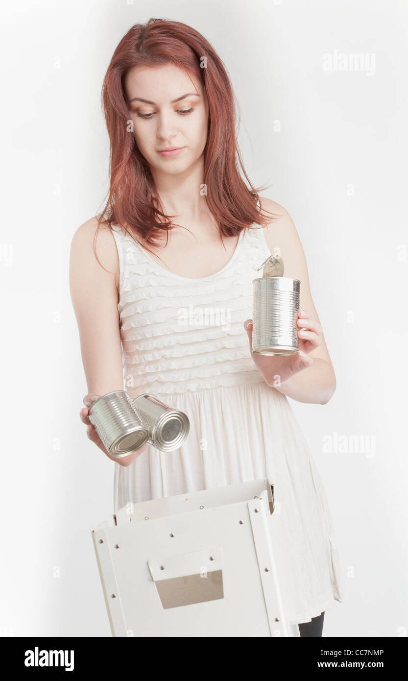 Young woman recycling tin cans Stock Photo